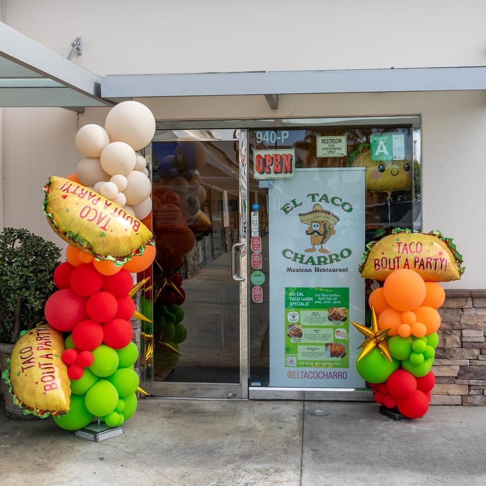 El Taco Charro Mexican Restaurant entrance decorated with colorful balloons and taco-shaped foil balloons.